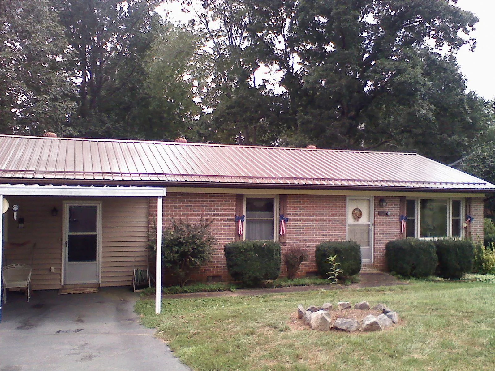 Bronze metal roof and carport on a brick ranch home — Roof Repair work by our crew in Cross